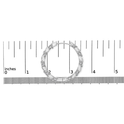 White metal hoop earring with alternating smooth and textured segments featuring round prong-set white gemstones, photographed from above on a ruler for size reference.