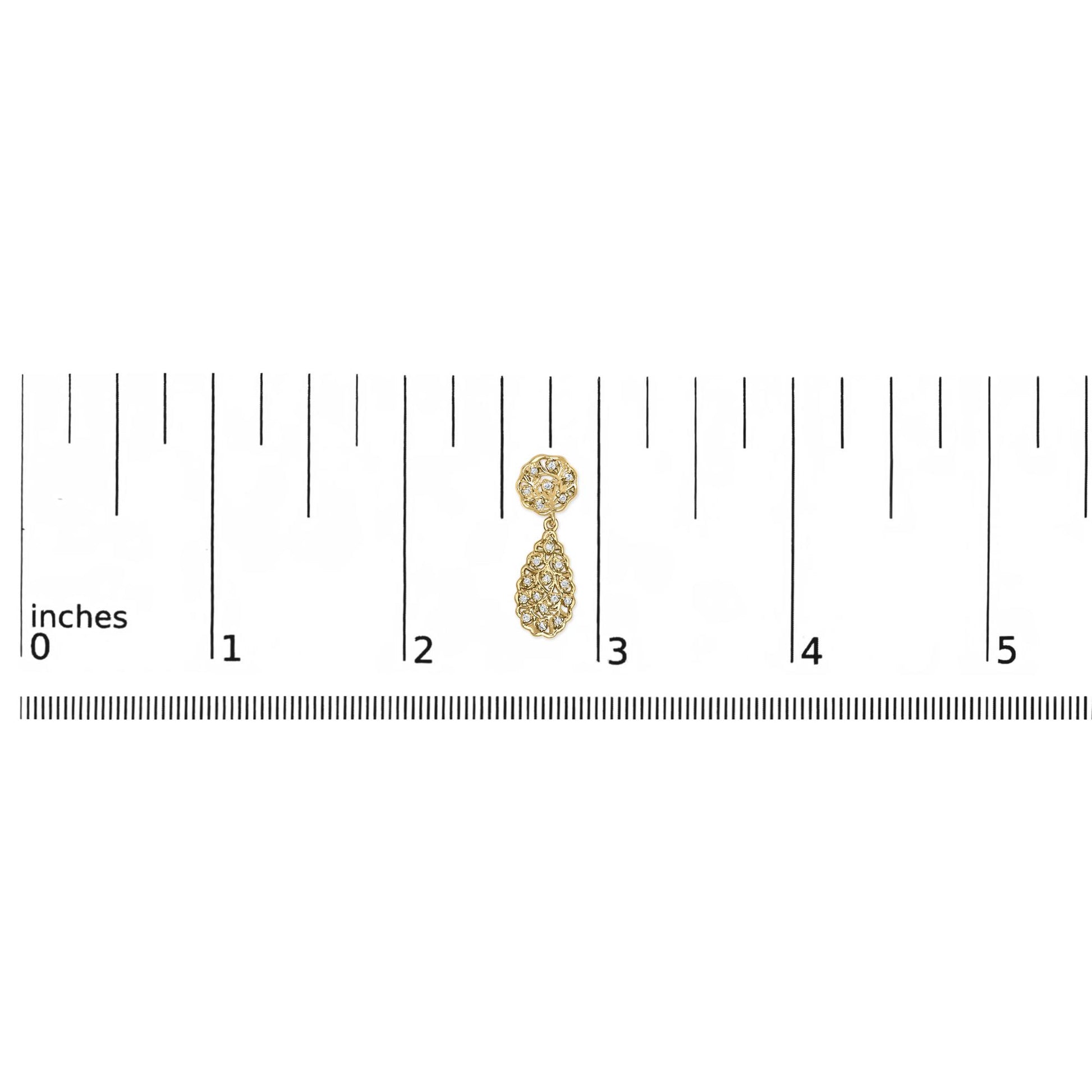 Yellow metal earring with round white gemstones in prong settings, shown on a ruler for size reference, front-facing angle.