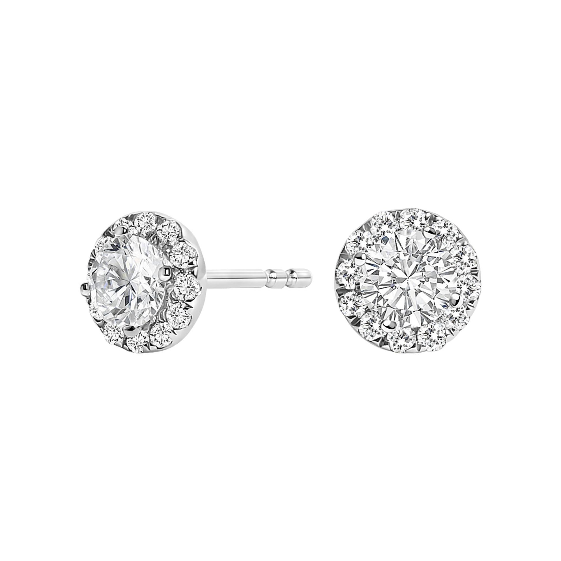 Front and side view of white metal stud earrings featuring a central round white gemstone surrounded by a halo of smaller round white gemstones.