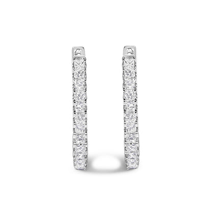 Pair of white metal hoop earrings with princess-shaped white gemstones in prong settings, shown in a front-facing close-up angle.