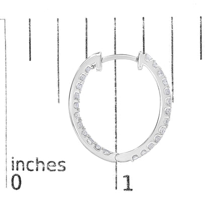 Close-up front angle of one white hoop earring with princess shape white gemstones in prong settings, shown on a measurement scale.