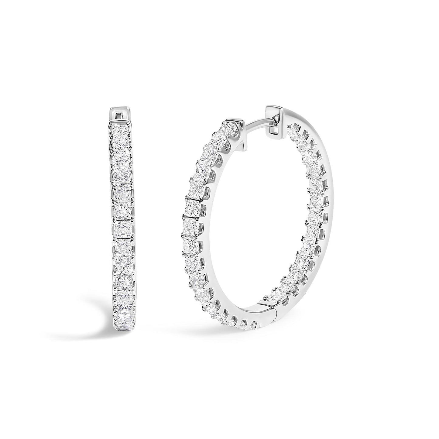 Close-up front and side angle of a pair of white metal hoop earrings adorned with prong-set white princess-shaped gemstones all around the visible outer edge.