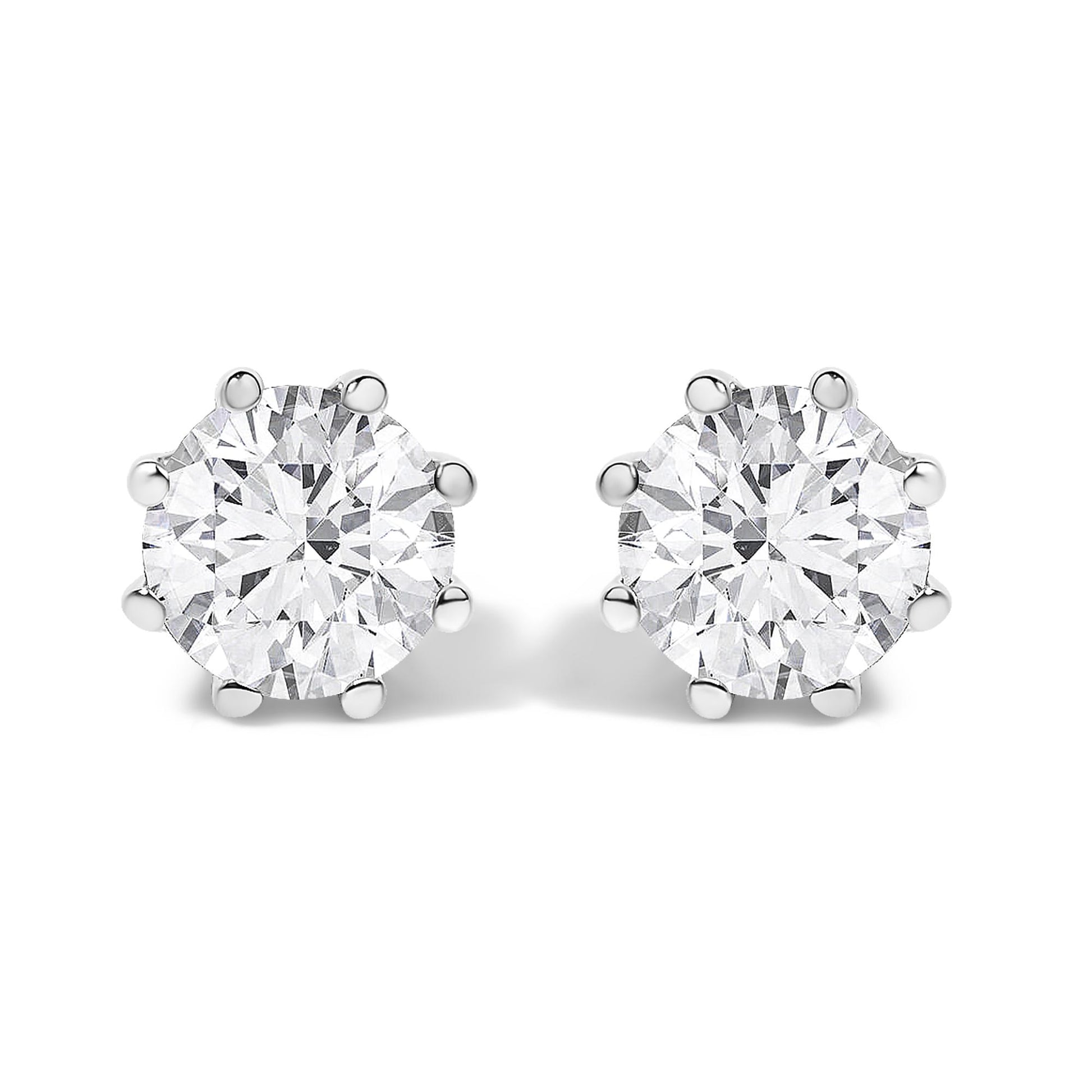 Front angled view of a pair of white metal stud earrings, each featuring a large round white gemstone in a prong setting.