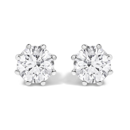 Front angled view of a pair of white metal stud earrings, each featuring a large round white gemstone in a prong setting.