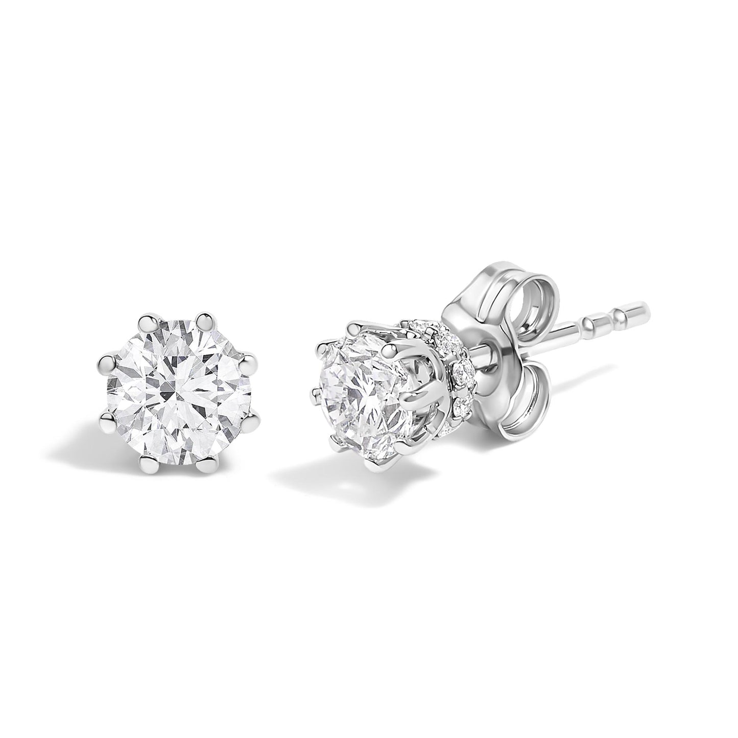 Close-up front and side view of a pair of white metal stud earrings with round white gemstones in prong settings.