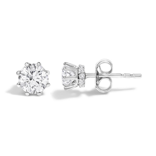 Pair of white metal stud earrings shown in front and side angles, featuring a large round white gemstone in a prong setting with smaller round white gemstones surrounding the base.