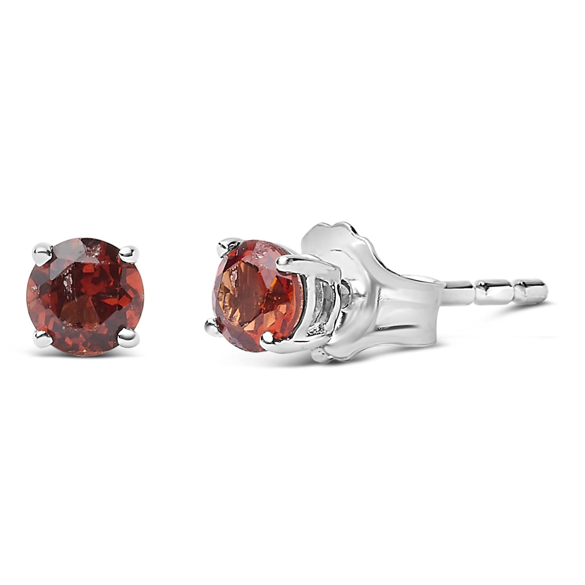 Pair of white metal stud earrings with round red gemstones in four-prong settings, shown from side and front angles.