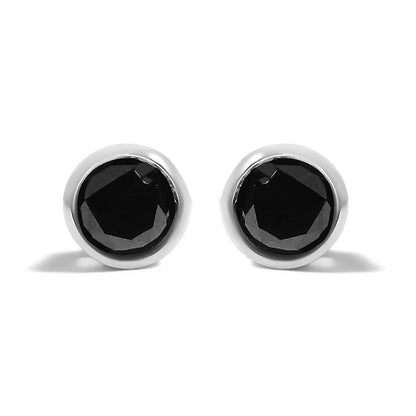 Front angle close-up of a pair of white metal stud earrings, each featuring a single round black gemstone in a bezel setting.