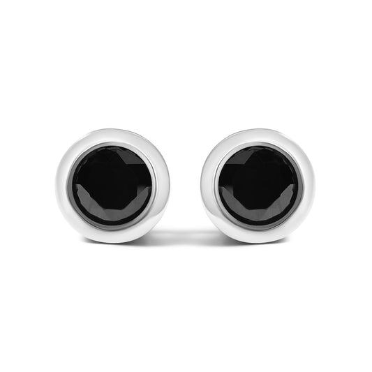 Front-facing close-up of round bezel set black gemstone stud earrings with white metal borders shown against a white background.
