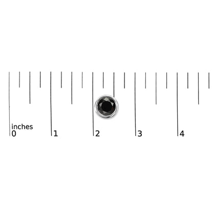Single white metal earring with round black gemstone in bezel setting, shown on a measurement scale from a top-down angle.