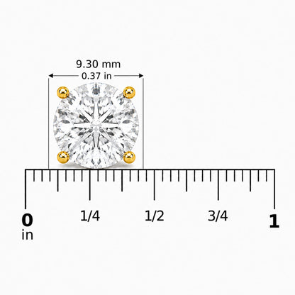 Close-up front view of a yellow metal stud earring with a round white gemstone in a four-prong setting, shown on a scale.