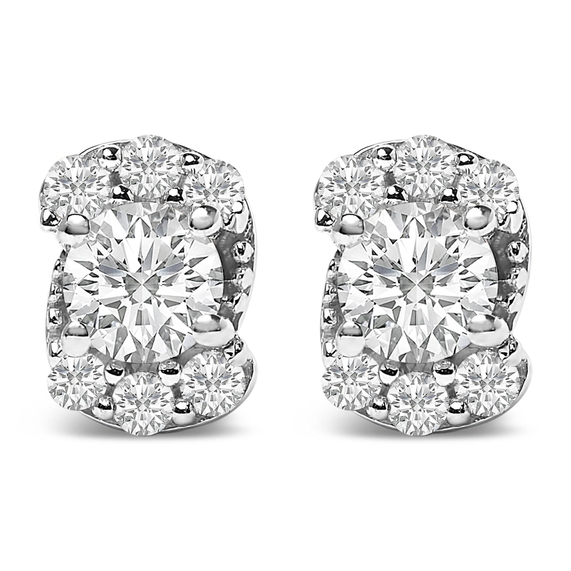 Close-up front view of a pair of white metal stud earrings featuring a large central round white gemstone surrounded by smaller round white gemstones in prong settings.