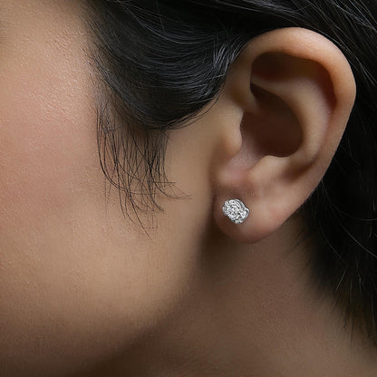 Close-up side view of a model wearing white metal stud earrings with clusters of round white gemstones in prong settings.