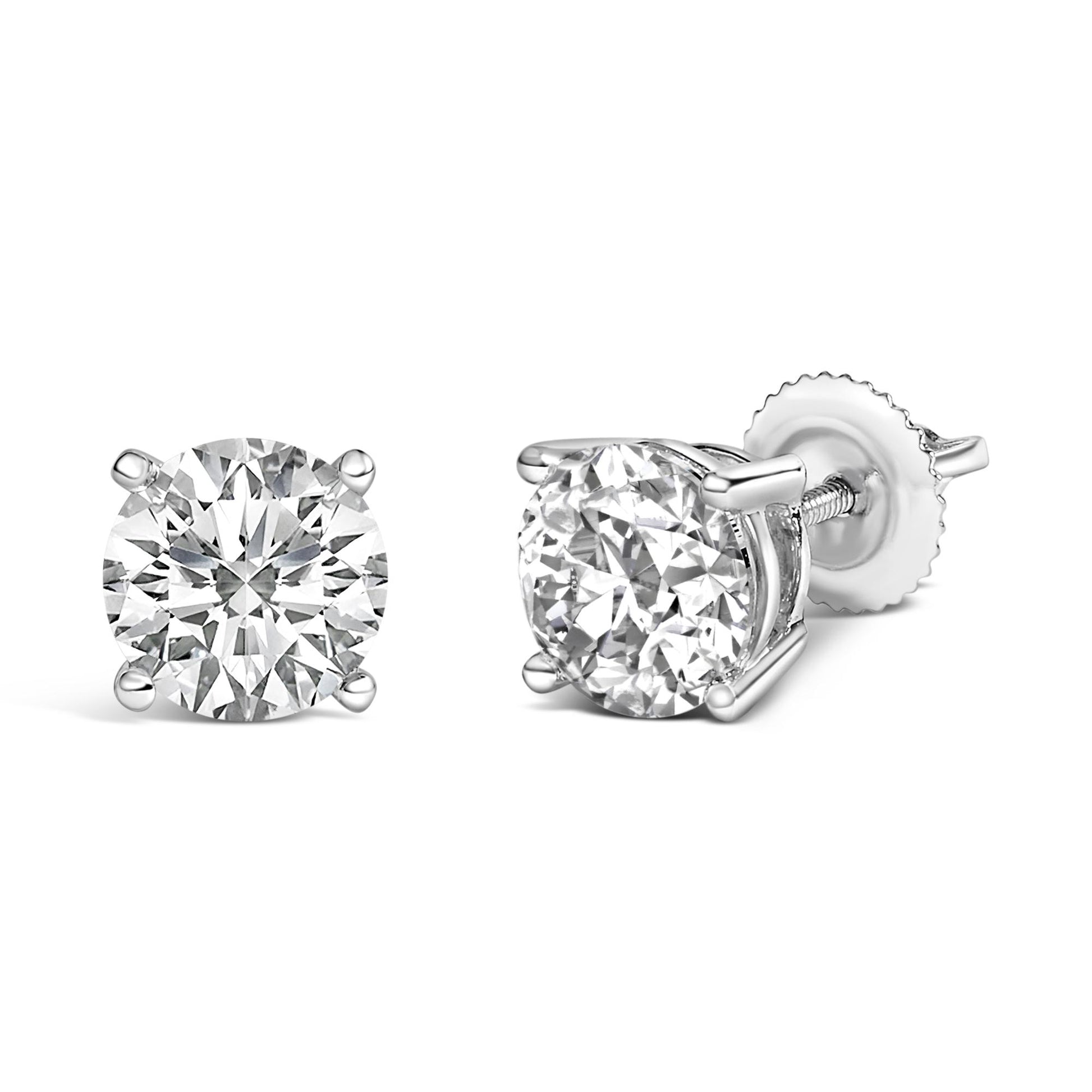 Pair of white metal stud earrings with round white gemstones in four-prong settings, one shown from the front and the other at a side angle.
