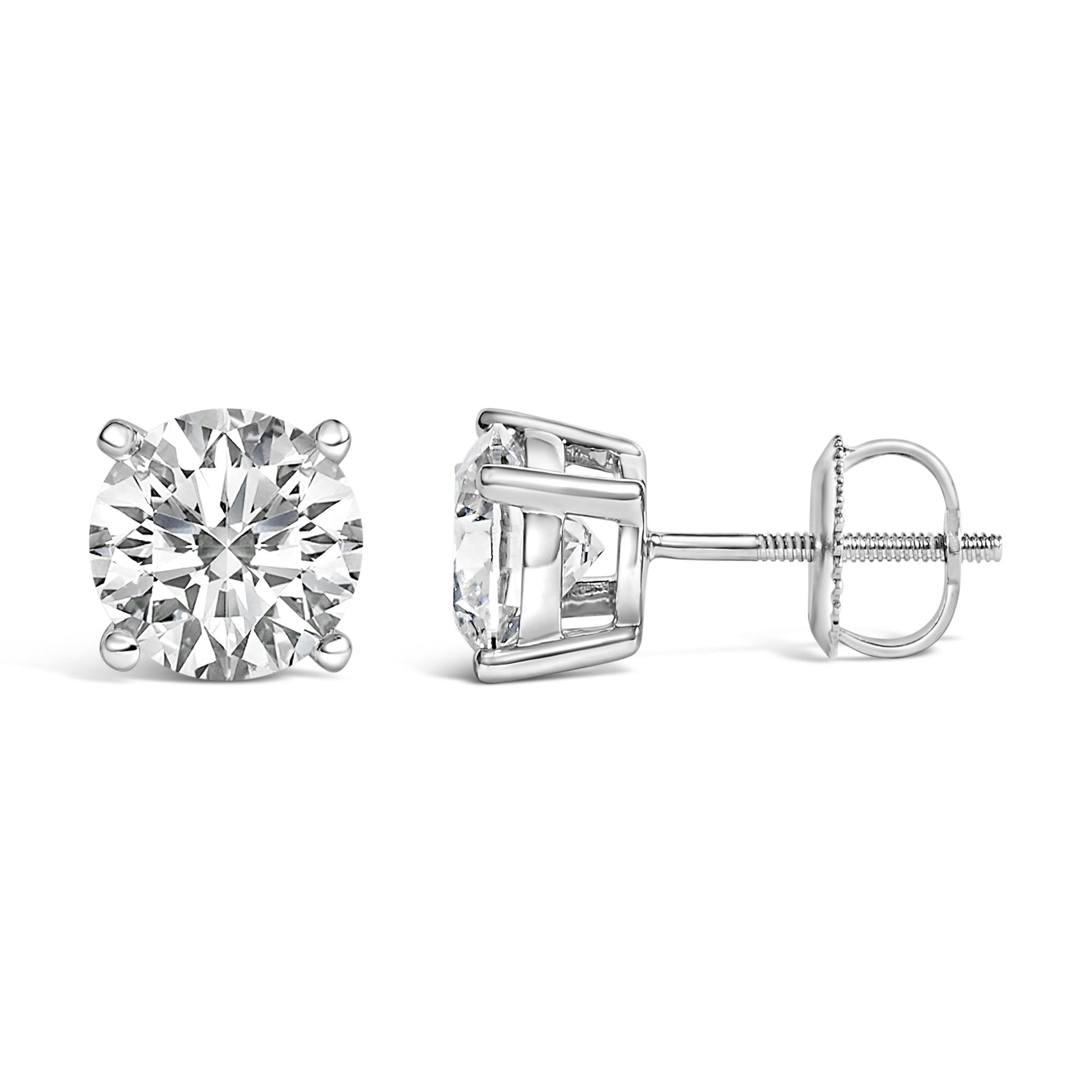 Pair of white metal stud earrings with round white gemstones in 4-prong settings, shown side and front angles on a white background.