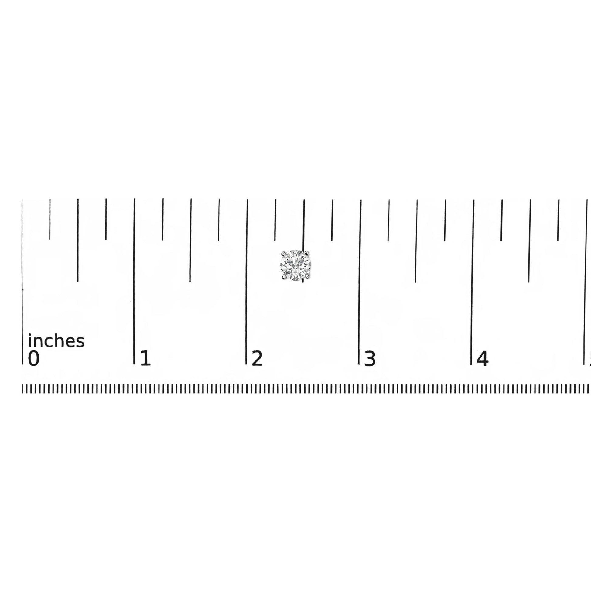 Close-up front view of a white metal round shaped earring with a white gemstone in a 4-prong setting, shown on a scale.