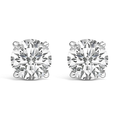 Close-up front angle of a pair of white metal stud earrings, each featuring a round white gemstone secured by a four-prong setting.