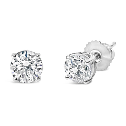 Close-up front and side angle view of a pair of white round gemstone stud earrings in a four-prong setting.