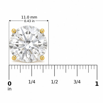 Close-up image of a single yellow metal round stud earring with a white round gemstone in a 4-prong setting, shown on a scale with measurements in millimeters and inches, front view.