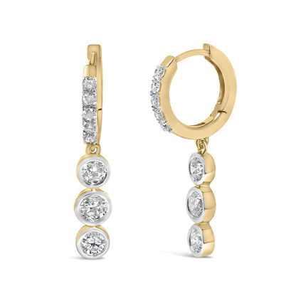 Close-up front and side view of yellow hoop earrings with prong and bezel-set white round gemstones in a vertical drop design, shown on a white background.