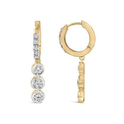 Close-up front and side angle of yellow metal hoop earrings with multiple white round gemstones in prong and bezel settings along the front, shown on a white background.