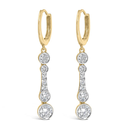 Close-up front view of a pair of yellow metal earrings featuring multiple round white gemstones in bezel and prong settings arranged vertically.