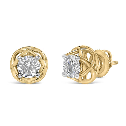 Pair of yellow metal stud earrings with round white gemstones in prong settings, shown from a slight top angle.