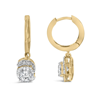 Close-up front and side view of yellow metal hoop earrings featuring a central round white gemstone surrounded by smaller white gemstones in a prong setting, shown against a white background.