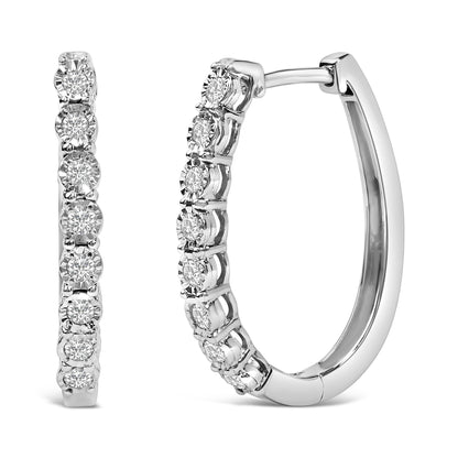 Close-up image of white metal hoop earrings with round white gemstones set in a row, shown from front and side angles.