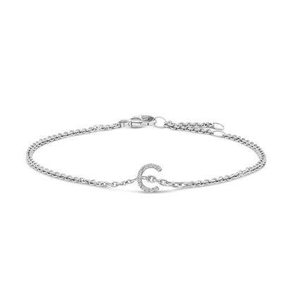 White metal bracelet with a delicate chain and a small horseshoe-shaped charm set with white round gemstones, shown from a front angle on a white background.