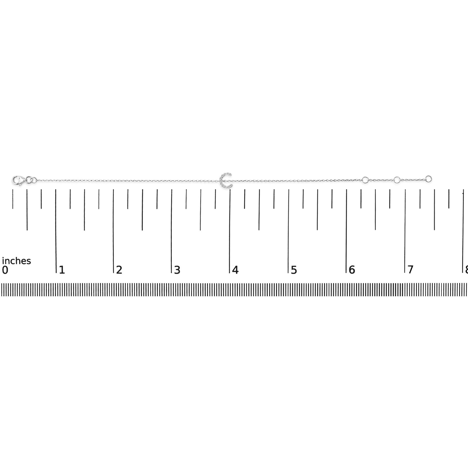 White bracelet with a crescent-shaped centerpiece set with small white gemstones, shown on a horizontal ruler scale, front-facing angle.