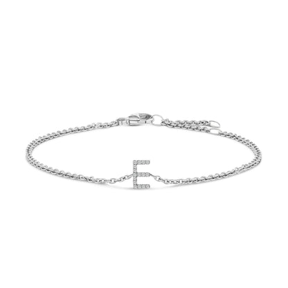 White metal bracelet with a delicate chain and a central letter 'E' adorned with small round white gemstones in micro-pave setting, shown flat on a white background from a top front angle.