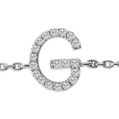 Close-up front view of a white metal bracelet featuring a 'G' shaped charm adorned with small round white gemstones in a micro-pave setting, attached to a link chain.