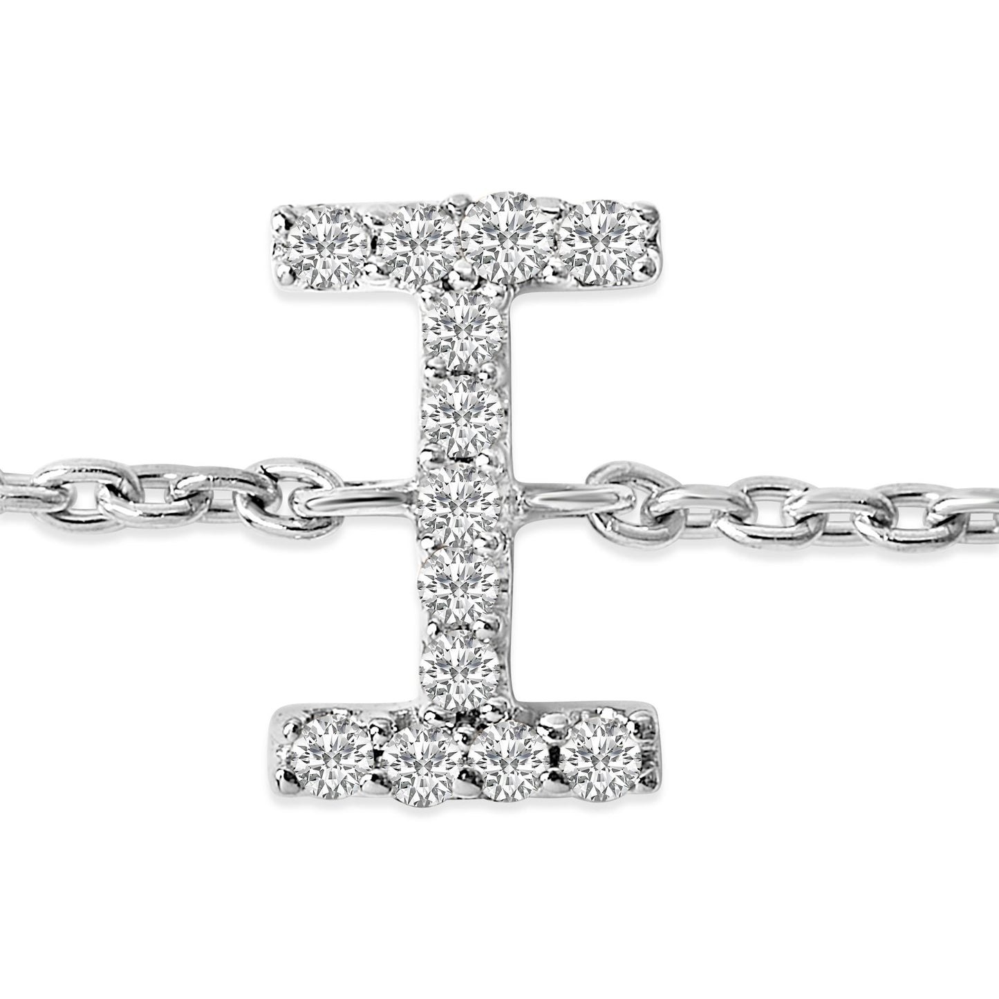 Close-up frontal shot of a white metal bracelet featuring a pendant shaped like the letter 'I' adorned with round white gemstones in a micro-pave setting, attached to a chain link band.