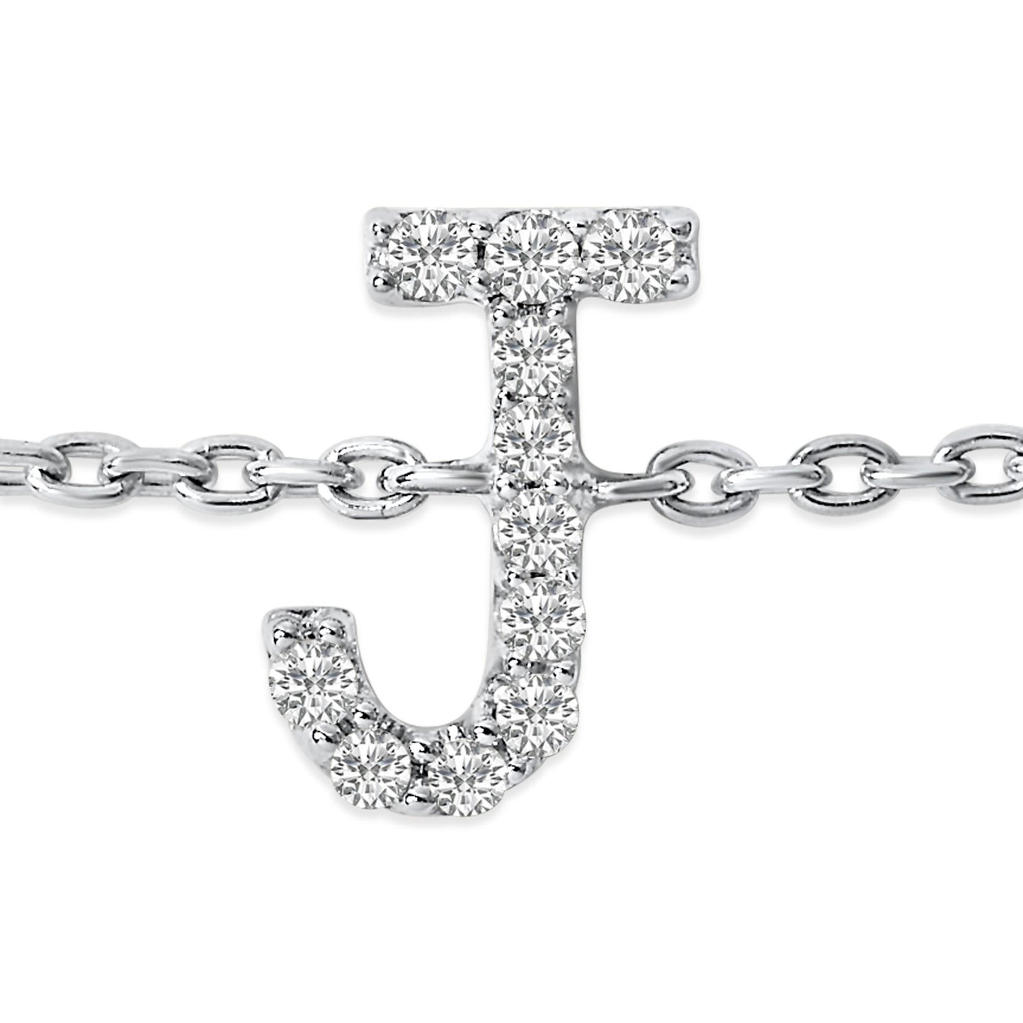 Close-up front view of a white metal bracelet featuring a 'J' shaped charm adorned with round white gemstones in a micro-pave setting, displayed on a white background.