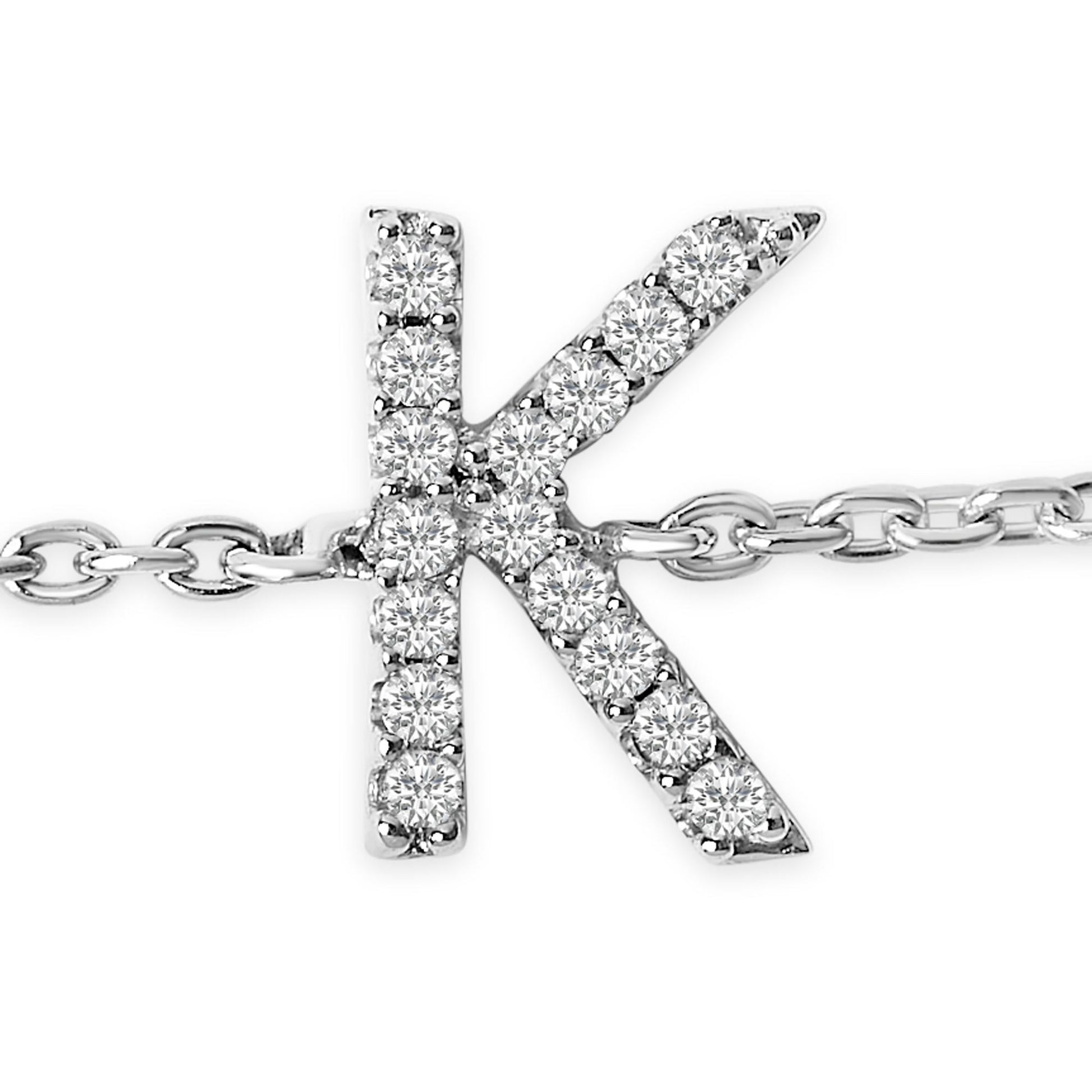 Close-up front view of white metal bracelet featuring a pendant shaped as the letter 'K' adorned with round white gemstones in a micro-pave setting.