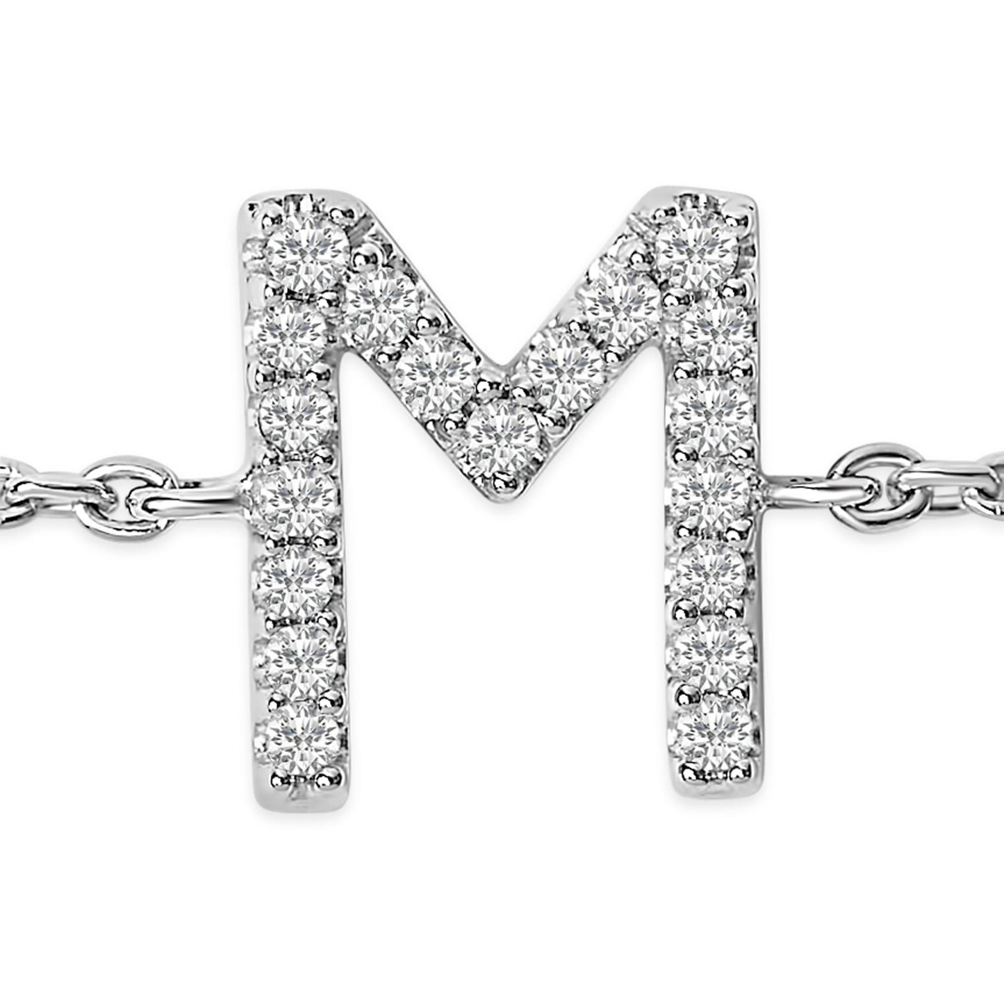 Close-up front view of a white metal bracelet featuring a letter 'M' pendant adorned with round white gemstones in a micro-pave setting.