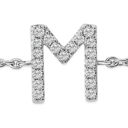 Close-up front view of a white metal bracelet featuring a letter 'M' pendant adorned with round white gemstones in a micro-pave setting.