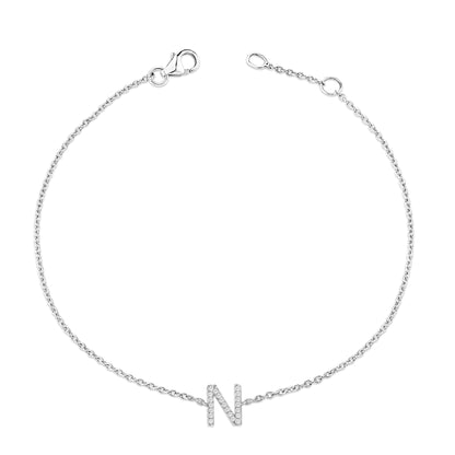 Bracelet with a delicate white chain and a letter 'N' charm adorned with small white gemstones in a micro-pave setting, shown flat from a top-down angle.