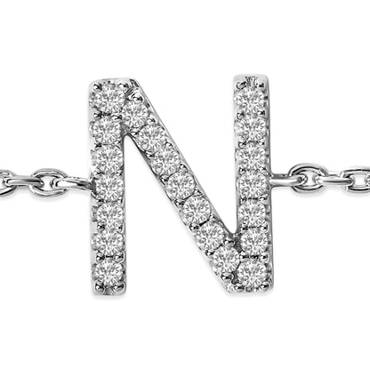 Close-up front view of a white metal bracelet with a letter N charm adorned with round white gemstones in micro-pave setting, attached to a chain.