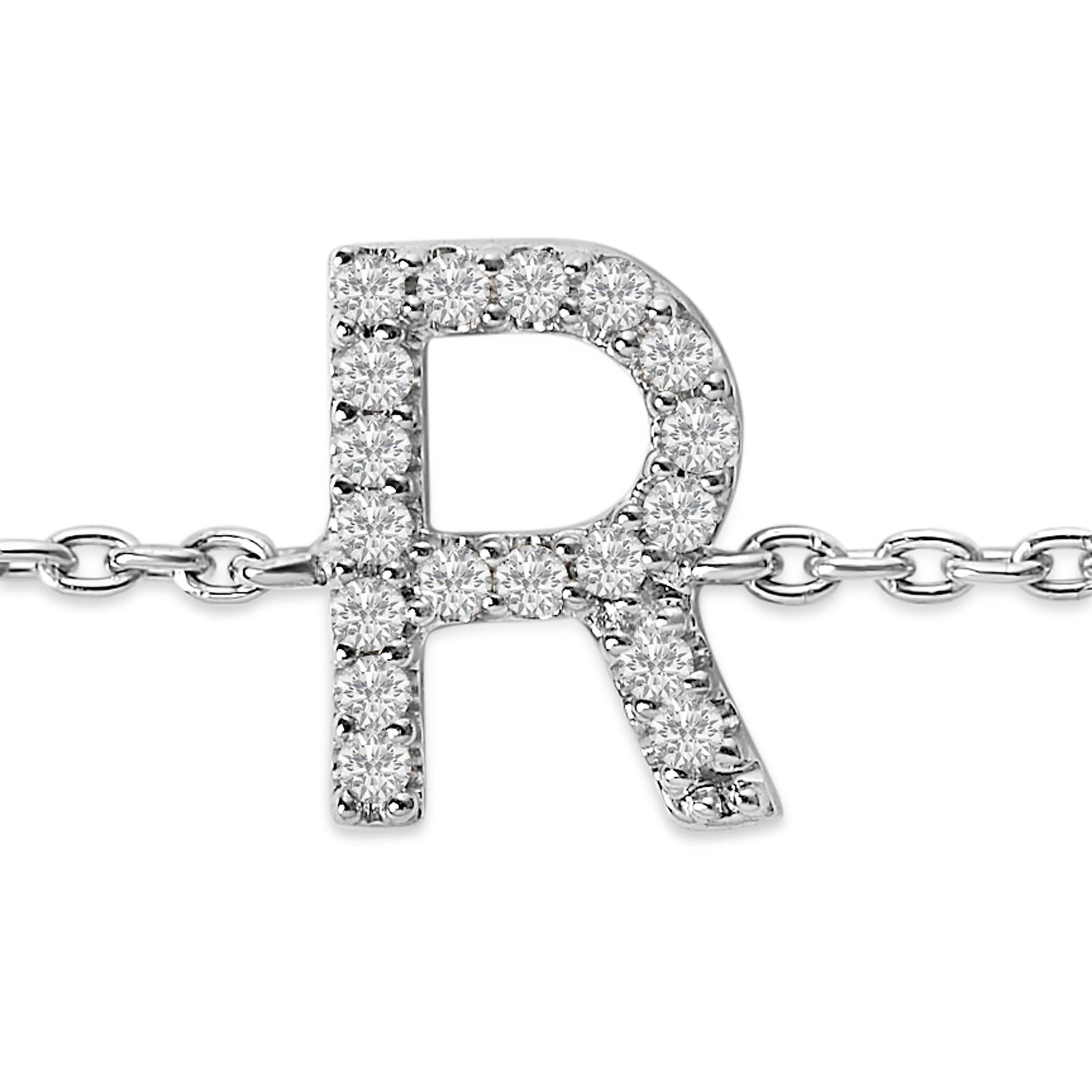 Close-up front view of a white metal bracelet chain featuring an uppercase letter 'R' pendant adorned with round white gemstones in a micro-pave setting.