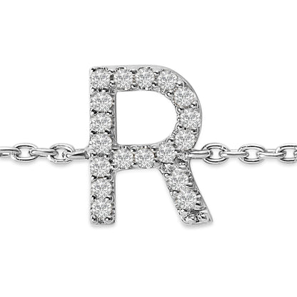 Close-up front view of a white metal bracelet chain featuring an uppercase letter 'R' pendant adorned with round white gemstones in a micro-pave setting.