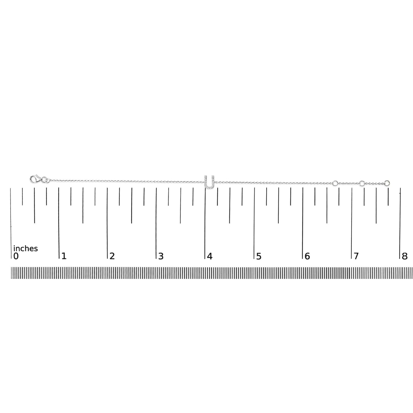 White bracelet with a central U-shaped charm set with white round gemstones in a micro-pave setting, shown on a ruler scale from a top-down angle.