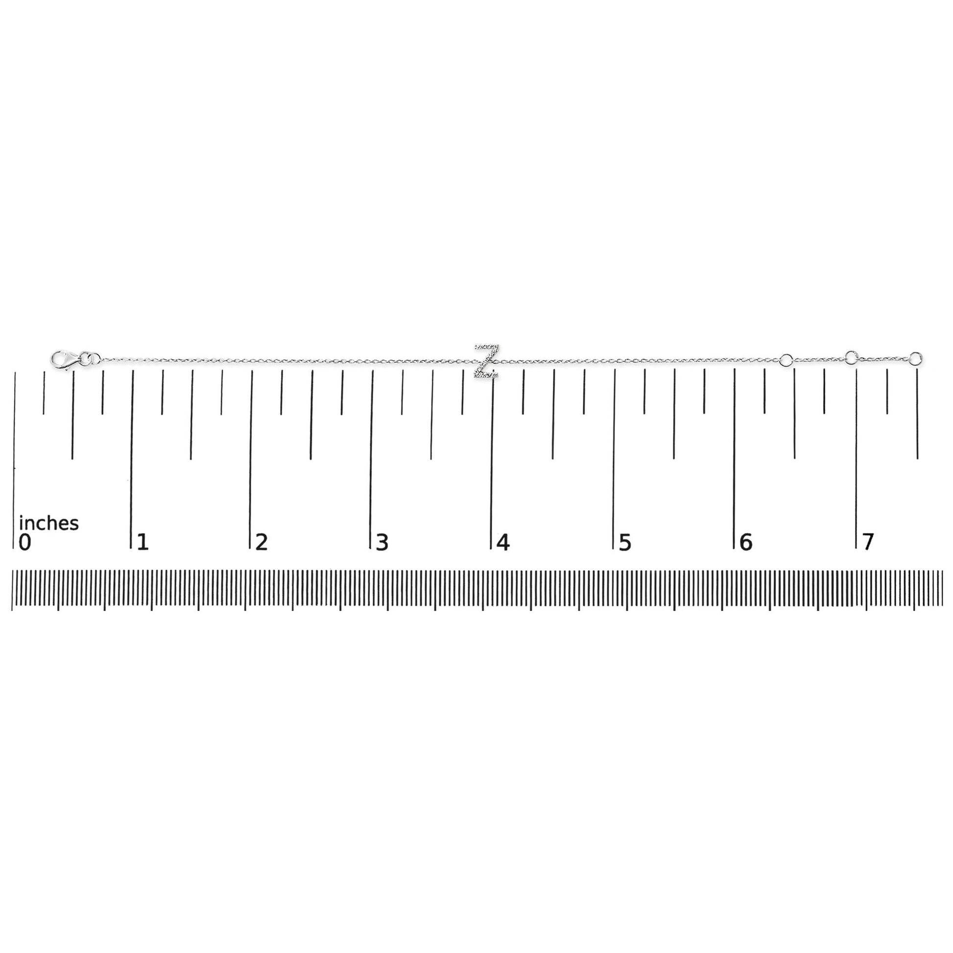 White metal bracelet with a 'Z' initial in micro-pave white gemstones, shown flat on a ruler for scale, top-down view.
