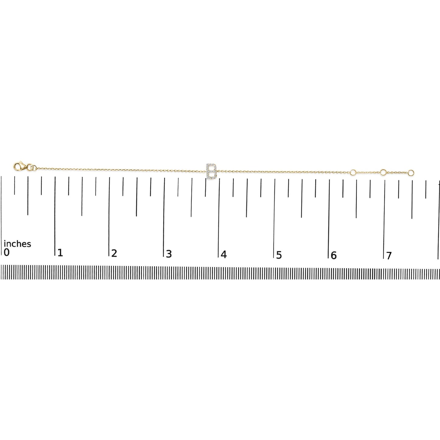 Yellow metal bracelet with a central letter-shaped charm adorned with round white gemstones in a micro-pave setting, shown on a ruler for scale from a top-down angle.