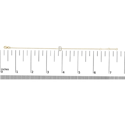 Yellow metal bracelet with a central letter-shaped charm adorned with round white gemstones in a micro-pave setting, shown on a ruler for scale from a top-down angle.