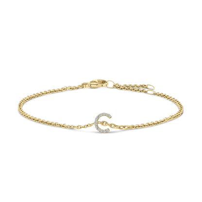 Yellow metal bracelet with a curved design element set with small white gemstones, displayed flat on a white background from a top front angle.