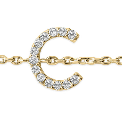 Close-up front angle of a yellow metal bracelet featuring a crescent-shaped charm adorned with round white gemstones in a micro-pave setting, attached to a chain link.