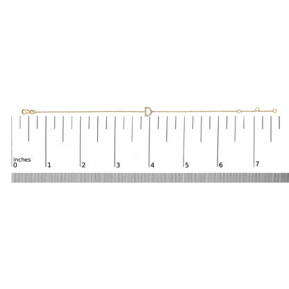 Yellow bracelet with a letter-shaped centerpiece adorned with small white gemstones in a micro-pave setting, displayed on a scale from a top-down angle.