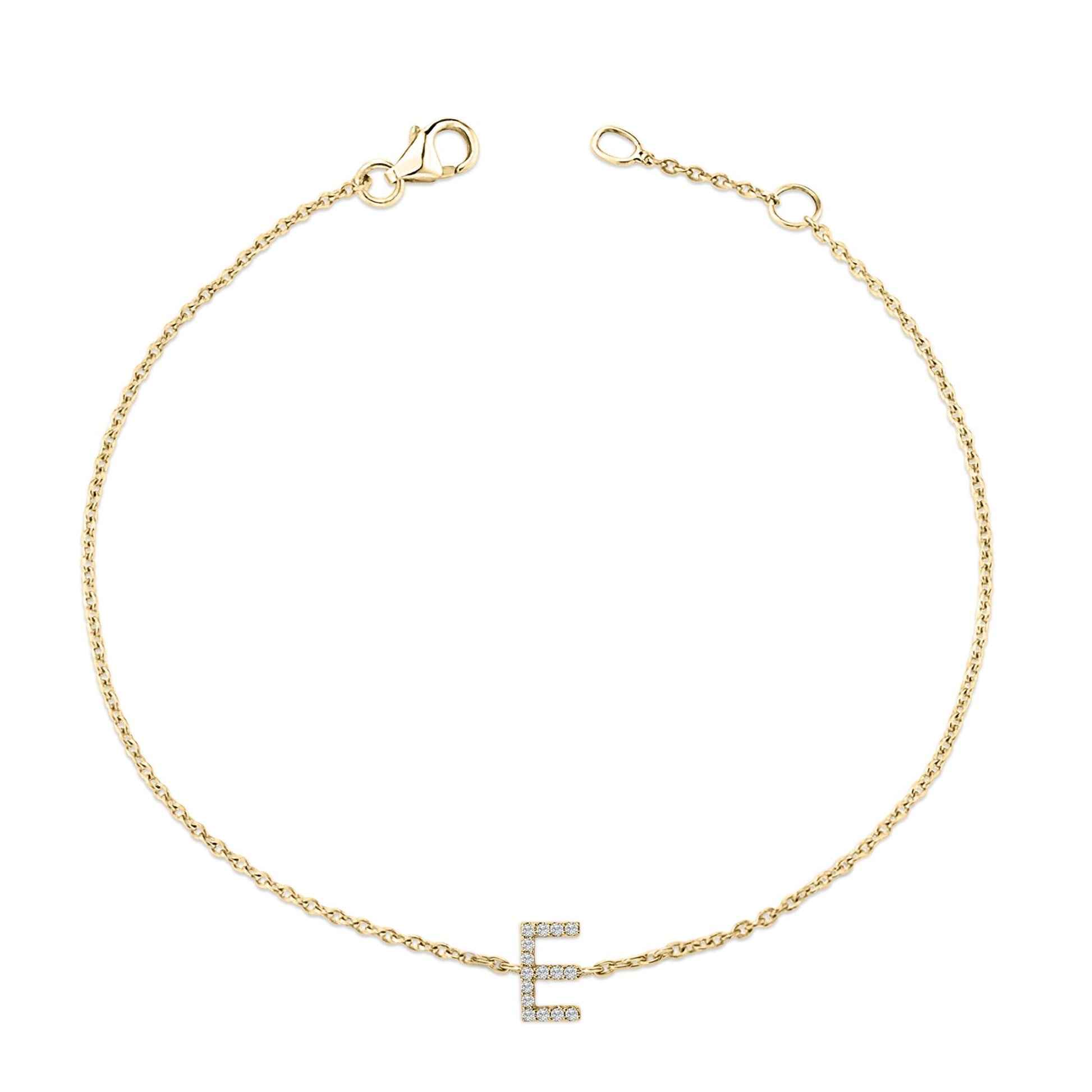 Close-up top view of a delicate yellow metal bracelet with a chain and an 'E' shaped charm adorned with white round gemstones in a micro-pave setting.